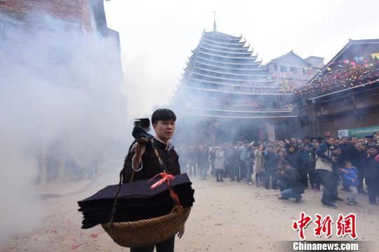 一名男子挑着自制侗布贺礼。 龚普康 摄